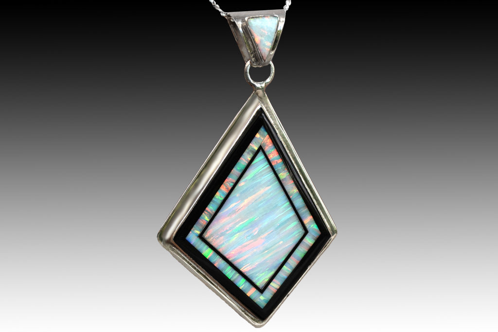280L - LARGE WHITE FIRE OPAL PENDANT INLAID WITH BLACK STONES